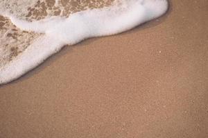 Top view of sand and sea water splash with copy space at a tropical clean summer beach photo