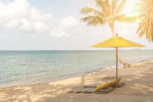 sombrilla y silla en un fondo de playa de verano tropical con espacio de copia cielo azul foto