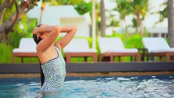 asiatische Frau genießt es, im Schwimmbad zu faulenzen