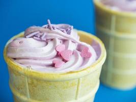Pink ice cream cone on blue background photo