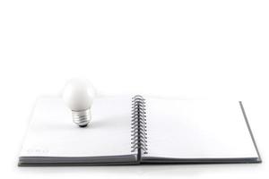 Notebook and lightbulb isolated on a white background photo
