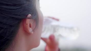 närbild av asiatisk kvinna dricksvatten efter en körning video