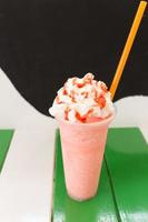 Sweet strawberry milkshake frappe, iced and milk blended with whipped cream photo