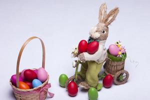 Huevos de Pascua y conejito sobre fondo blanco. foto