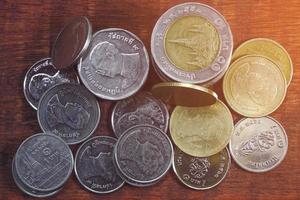 Pila de alto ángulo de monedas de baht tailandés sobre una mesa de madera, concepto de crecimiento financiero foto