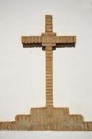 Cruz cristiana de ladrillos sobre un fondo blanco.