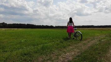 jovem em um campo aberto com uma bicicleta video