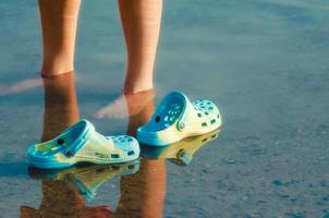 zapatos azules y pies en el agua foto