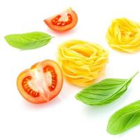 Concepto de comida italiana de fettuccine con tomate y albahaca aislado sobre un fondo blanco.