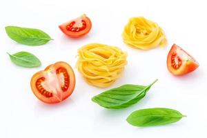 Concepto de comida italiana de fettuccine con tomate y albahaca aislado sobre un fondo blanco.
