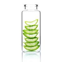 Homemade skin care with aloe vera slices in a glass bottle isolated on a white background photo