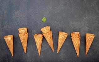Lay Flat de conos de helado sobre un fondo de piedra oscura, cono de helado crujiente con espacio de copia para el diseño del menú de dulces foto
