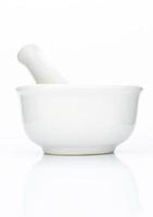 Close up of white ceramic mortar and pestle isolated on a white background photo