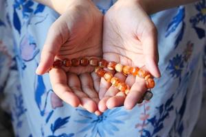 Close up of woman's hands praying with beads photo