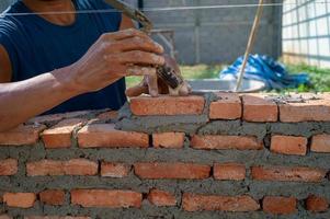 Hands of worker holds the trowel and installs bricklayers photo