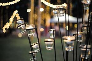 Selective focus on candles in small glasses with blurred bokeh lights in background photo