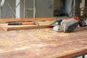 Selective focus on carpentry tools on the dirty wooden desk with sawdust photo