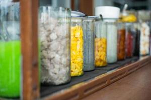 Selective focus of various kind of dessert topping in the glass jars photo