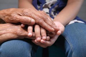 Child holding hands with elderly woman photo