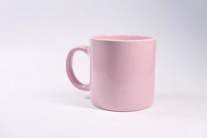 Taza de café de color rosa sobre fondo blanco. foto