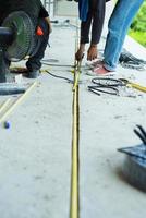 Workers installing the electrical wire and pipe in the house under construction photo