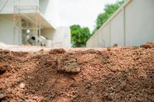 Primer plano de la textura del suelo en el suelo con el sitio de construcción borrosa en segundo plano. foto