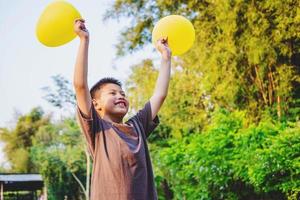 niño sosteniendo globos amarillos foto