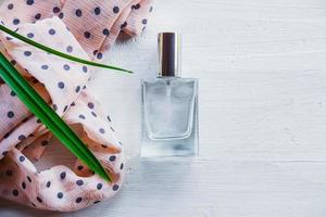 Perfume flat lay with a plant and ribbon photo