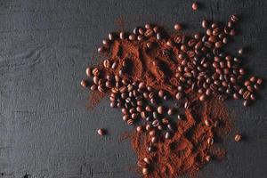 Ground coffee and coffee beans on a dark background photo
