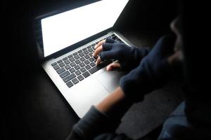 mano escribiendo en el teclado de la computadora en la oscuridad foto