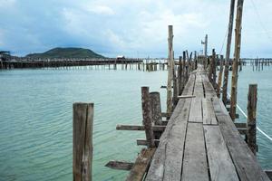 Native fisherman house and traditional fishing farm at the coast of sea with old wooden walkway photo