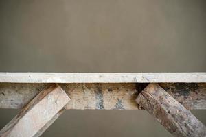 Abstract texture and background of closeup wooden table with wet plastered cement wall in background photo