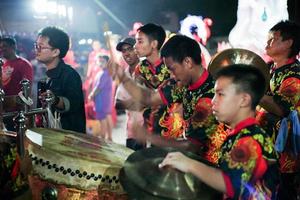 Ratchaburi, Thailand 2020 - Selective focus on portrait of male drummer with traditional band in Chinese New Year celebration photo