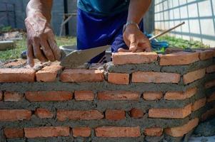 Closeup texture and background of orange bricklayers installed by worker at the construction site photo