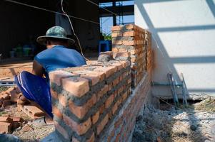 Closeup texture and background of orange bricklayers installed by worker at the construction site photo