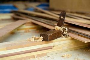 Primer enfoque selectivo en el sacapuntas de madera vintage de carpintero para fregar la madera. La herramienta tradicional de manitas en la pila de madera con aserrín. foto