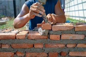 Closeup texture and background of orange bricklayers installed by worker at the construction site photo