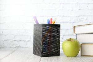 Apple and pens on a desk top photo