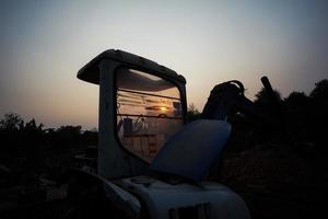 silueta de tractor y vehículo en el sitio de construcción foto