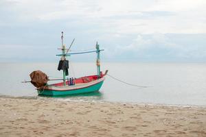 Pequeño barco de pesca tradicional flotando en el mar. foto
