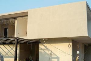 Empty cement wall of the house under construction with blue sky in background photo