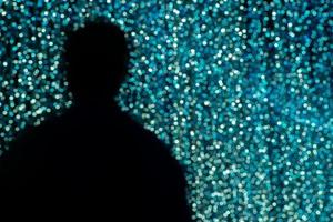 Silhouette back portrait of man with blurred glittering bokeh in background photo