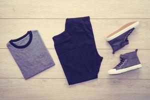 T-shirt with pants and shoes on wooden background photo