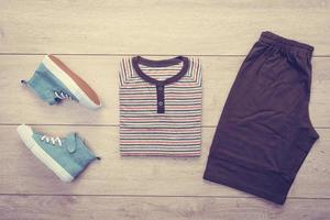 T-shirt with pants and shoes on wooden background photo