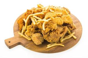 French fries and fried chicken on wooden plate photo