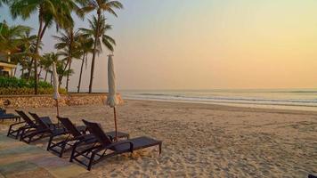 Sonnenschirme und Liegestühle am Strand bei Sonnenuntergang video