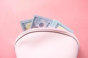 Close up of cash in wallet on pink background photo
