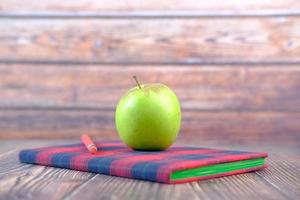 Apple on notepad on table photo