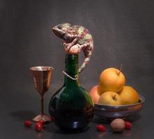 Chameleon on a decanter with fruit still life photo