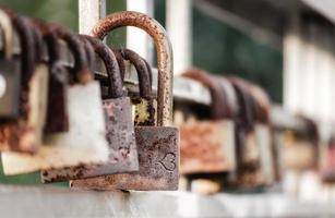 Rusty locks on a metal fence